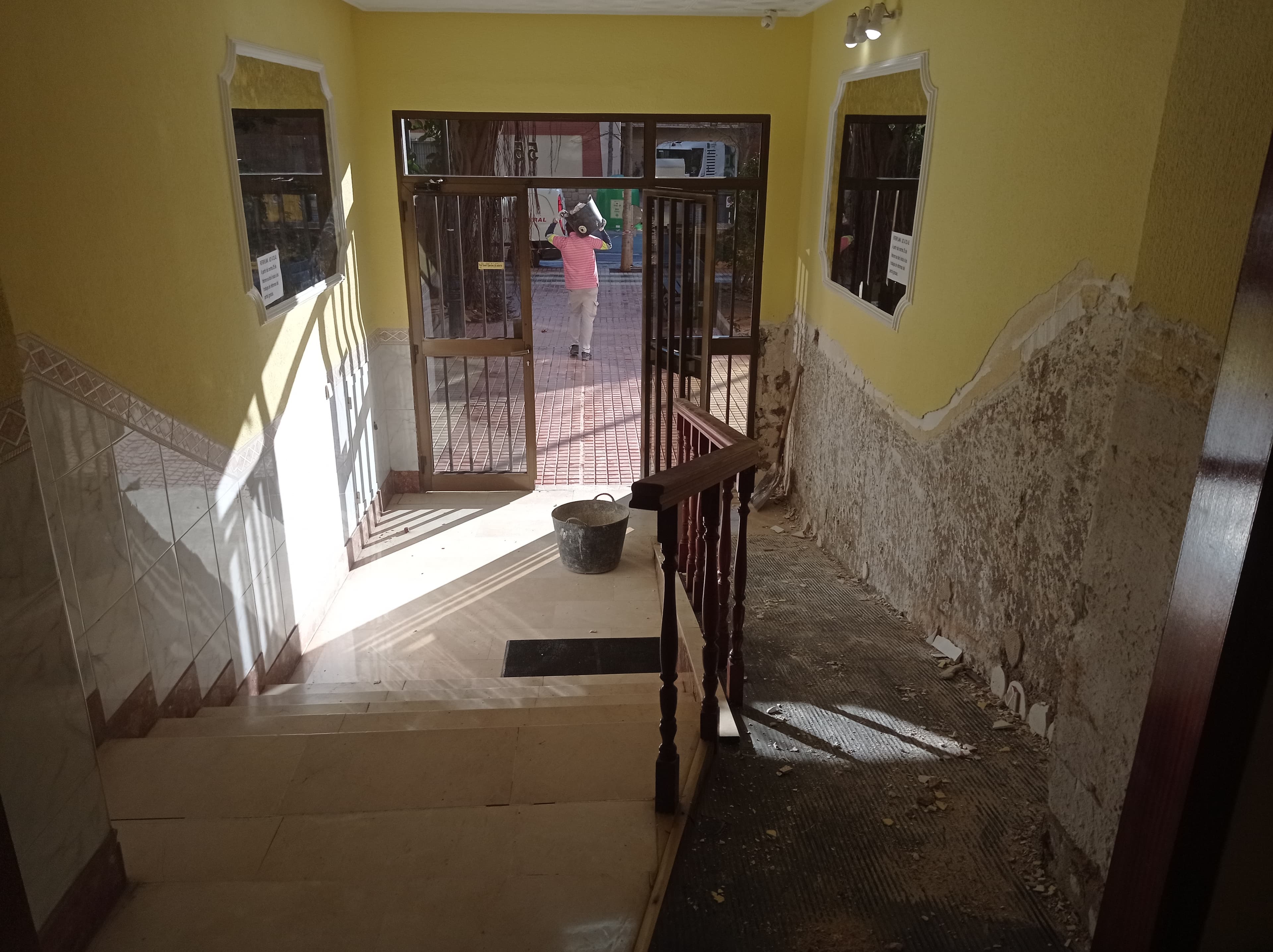 Portal de la comunidad en Cartagena antes de la reforma, con revoco deteriorado